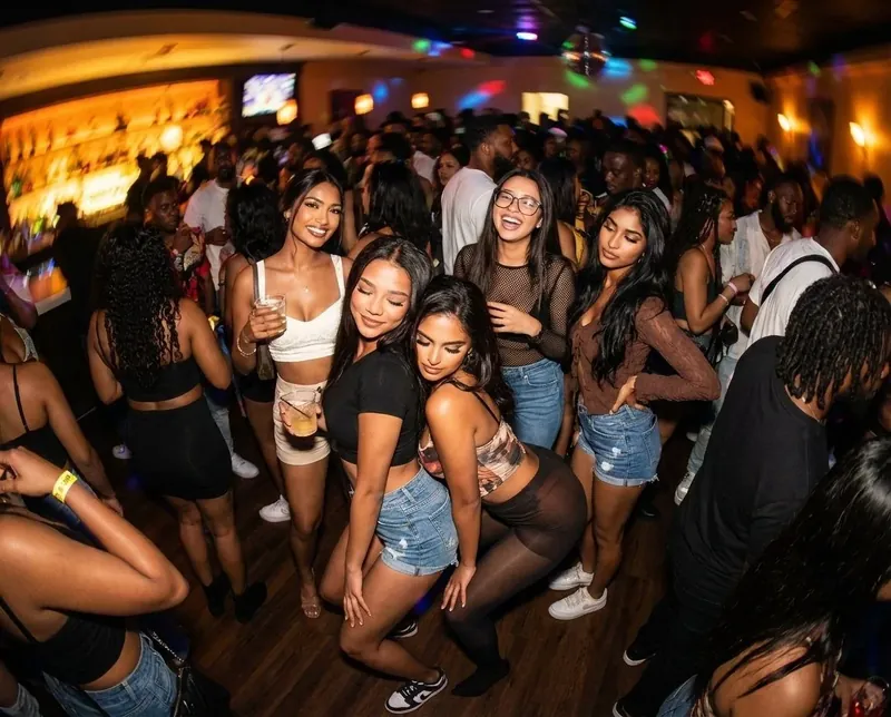 Late-night crowd dancing under disco lights at a Soca Forever fete